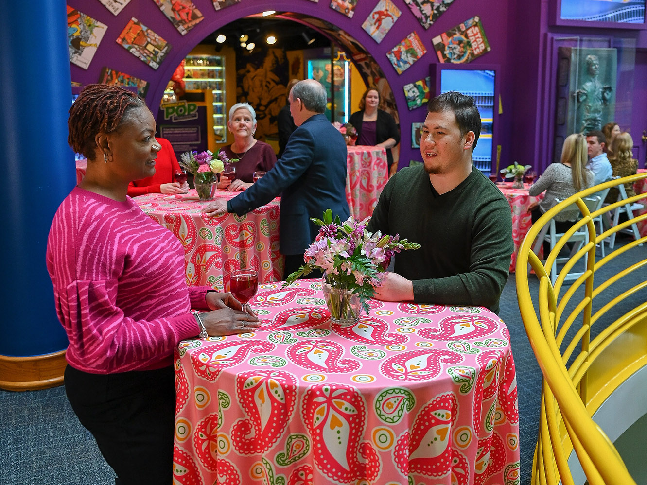 People sitting at tables outside American POP exhibit.